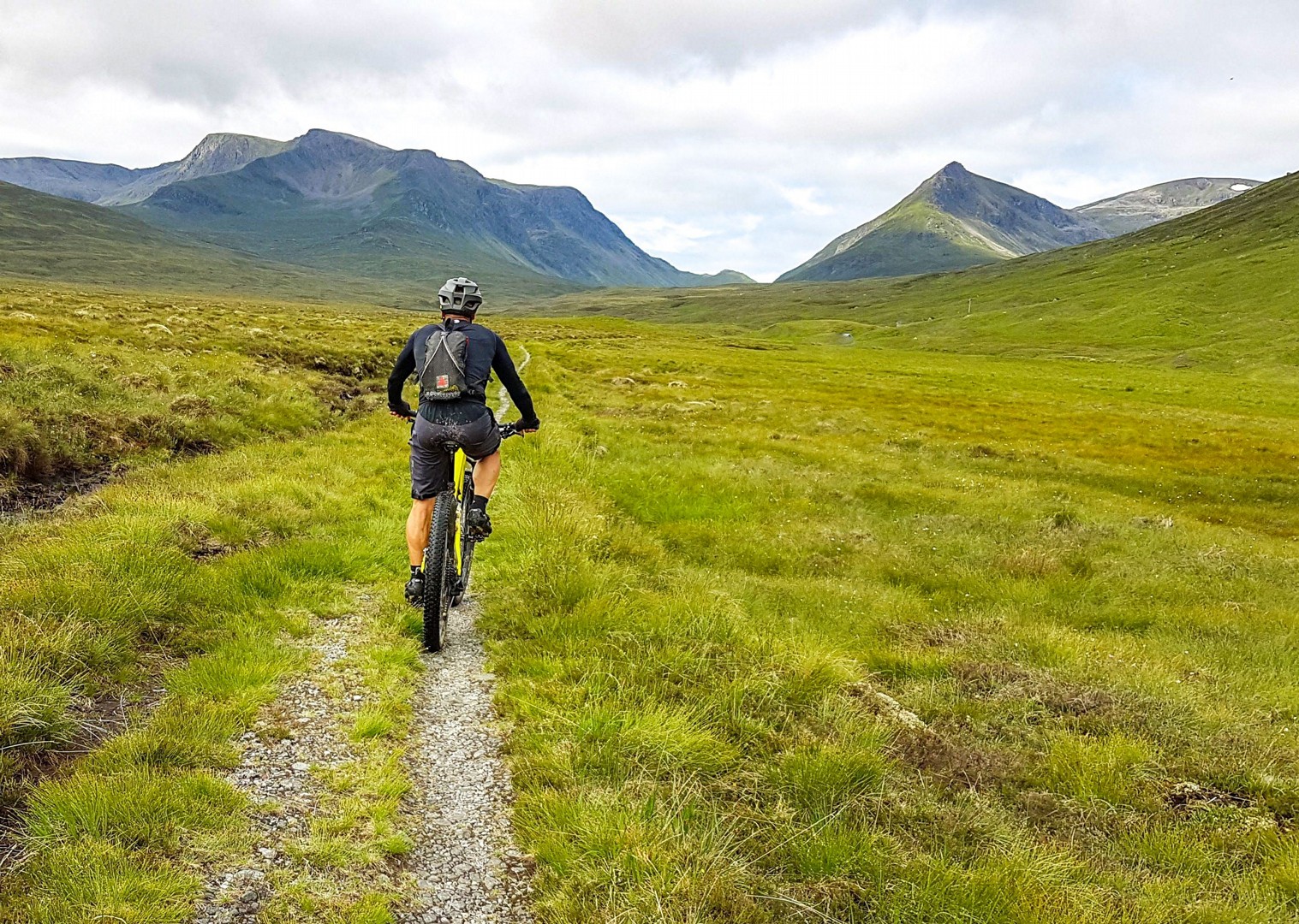 Biciclist pedalând prin peisajul scoțian